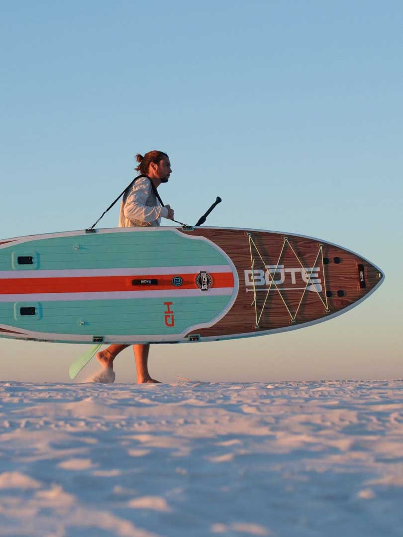 Man carrying a standup paddleboard