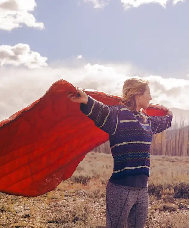 Woman holding a blanket in the wind