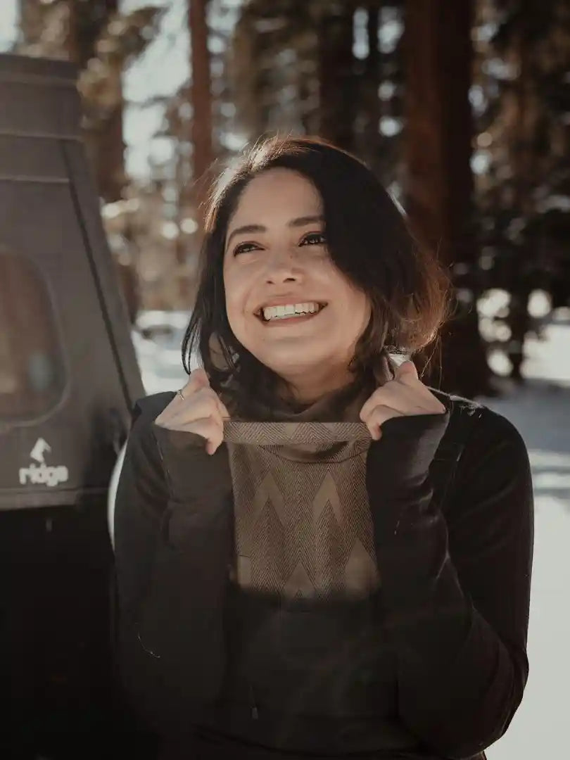 Woman standing in the snow smiling