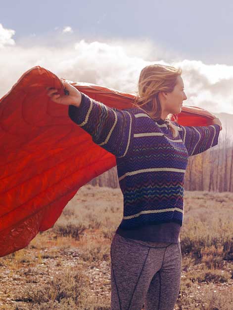 Woman holding up a blanket in the wind